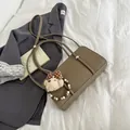 Retro brown oil wax leather baguette bag with plush teddy bear charm on white sheet - Elephant Gray With Charm