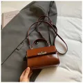 Detalle de un mini bolso bandolera vintage marrón con cierre giratorio de metal plateado fino - Marrón