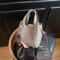 Borsa a secchiello taupe in pelle a grana litchi con ciondolo e tracolla regolabile - con portachiavi / Grigio