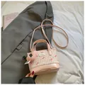 Mini borsa a secchiello a scacchi rosa con fiocco e ciondolo a cuore su blazer grigio - Grande / Rosa Grande