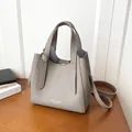 Borsa a secchiello minimalista in pelle grigia testurizzata con stampa e tracolla - senza ciondolo / Grigio