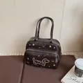 Borsa a mano marrone con sagoma di bassotto e stelle dorate in un ambiente accogliente - Marrone