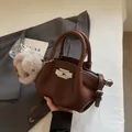 Brown lychee grain leather crossbody bag with silver lock and plush charm accessory - Coffee With Pendant