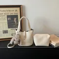Chic beige lychee textured leather bucket bag set with a cute plush doll keychain - With Pendant / Off White