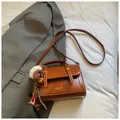 Braune Vintage-Umhängetasche aus Kunstleder mit Metallverschluss und süßen Anhängern - Mit Anhänger / Braun