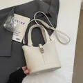 Chic beige bucket bag with litchi grain texture featuring top handle and adjustable strap - Without Pendant / Off White