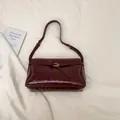 Retro Schultertasche aus burgunderrotem Lackleder mit goldener Spiralschnalle - Rot