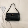 Glossy black patent leather underarm shoulder bag with golden horseshoe metal buckle - Black