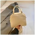 Elegant minimalist cream square handbag with dual handles and adjustable strap - White