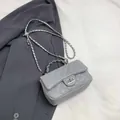 Light grey quilted crossbody bag with chain strap and metallic lock on grey blazer - Gray