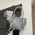 Mini borsa a secchiello azzurra in pelle con elegante ciondolo fiocco in pizzo e perle - con portachiavi / Blu