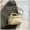 Creamy white lychee leather handbag with a cute teddy bear charm and adjustable strap - White With Pendant