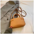 Caramel lychee textured handbag with adjustable strap in a minimalist office setting - Brown No Pendant