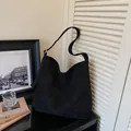 Minimalist black oversized suede tote bag featuring a wide shoulder strap in premium finish - Black