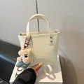 Schicke cremeweiße Handtasche mit Silbernieten und süßem Teddybär Plüschanhänger - Weiß