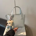 Hellblaue quadratische Handtasche mit Plüschbär-Anhänger und MIAOSHE-Markenlogo - Blau