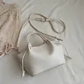 Minimalist cream white crossbody tote bag with drawstring details and leather texture - White