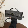 Sac sous le bras noir chic avec clous argentés et ferrures dorées pour mode de bureau - Patchwork Noir et Blanc