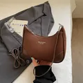 Brown lychee leather crescent shoulder bag with white lettering on grey blazer - Brown