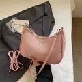 Pink lychee texture crescent shoulder bag with adjustable strap and chic urban branding - Pink