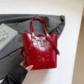 Red patent leather bucket bag with silver studs and a gothic metal cross pendant - Red