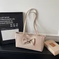 Beige woven tote bag featuring a large bow accent and minimalist shoulder straps - Khaki