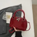 Glanzende donkerrode schelptas met hartvormige hanger en verstelbare schouderband - Rood