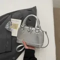 Silver shell-shaped crossbody bag with metallic finish and heart key charms - Silver