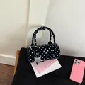 Detailed macro view of black polka dot boston bag with soft texture and star chain charm - Black