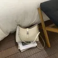 Bolso tipo cubo blanco crema con cadena plateada y cierre de giro metálico de lujo - Vainilla