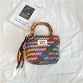 Multicolor woven handbag with bamboo handles and decorative star pendants on a white fabric - S / With Pendant / Multicolor