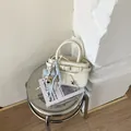 Detail der cremefarbenen Tasche mit Schleife, Bärenanhänger und Metallstern-Dekor - Weiß Mit Bärenanhänger