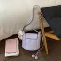 Λεπτομέρεια λιλά τσάντα bucket από PU με κάθετη ραφή και κρεμαστό αρκουδάκι - Μοβ Με Μενταγιόν