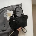 Elegante borsa a secchiello intrecciata nera con manici rotondi e tracolla regolabile - Nero