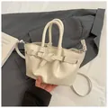 Cream bucket bag in glossy leather with silver buckle and crossbody strap detail - White