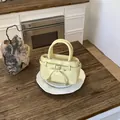 Light yellow glossy leather mini handbag with top handles and silver zipper closure - Yellow (Without Pendant)