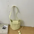 Minimalist cream yellow bucket bag featuring a sleek crossbody strap and woven knot charms - Yellow Without Pendant