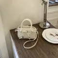 Creamy white crossbody bag with bow tie and star pendant on a vintage wooden desk - White (Without Pendant)