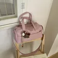 Detailed texture of pink pebble leather bag with a cute plush horse charm on a chair - With Charm / Pink