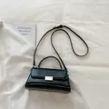 Borsa a mano nera in pelle lucida con fibbia in metallo e tracolla regolabile - Nero