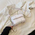 Light pink woven crossbody bag with chunky metal chain and ball charms on a white blazer - With Pendant / White