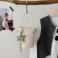 Beigefarbene Beuteltasche aus Leder mit braunem Pony-Anhänger an einem rustikalen Holzstab - Cremeweiß mit Anhänger