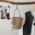 Elegante beige Leder-Beuteltasche mit Tragegriff und dekorativem Schaukelpferd-Anhänger - Khaki Mit Anhänger