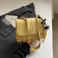 Minimalistische hellgelbe Ledertasche mit Lychee-Muster und stylischem Schnauzer-Anhänger - Mit Anhänger / Gelb