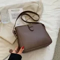 Bolso tipo cubo minimalista en cuero marrón oscuro para mujer con correa y hebilla - café