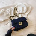 Navy blue quilted shoulder bag featuring gold clover clasp and woven chain strap - Blue