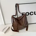 Minimalist dark brown leather shoulder bag with wide strap and spacious bucket shape - Coffee