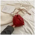 Detail der roten gesteppten Eimertasche mit Kordelzug und goldenem Kettenriemen - Rot