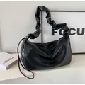 Dettaglio della borsa hobo nera con tracolla a pieghe e ciondolo zip in argento - Nero