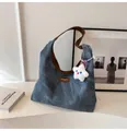 Detail van blauwe canvas hobo tas met lederen riem, logo patch en ster pluche hanger - Met Hanger / Blauw